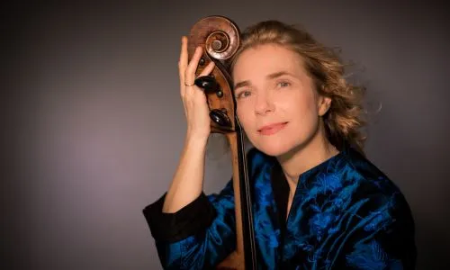Portrait de Claire Oppert posant avec son violoncelle.