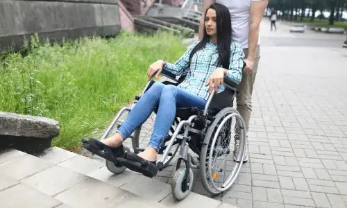 femme en fauteuil a Rome aid&eacute;e aux marches