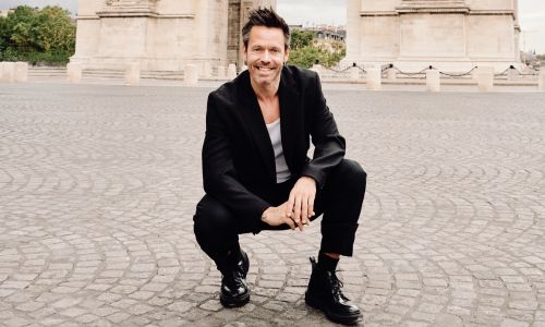 Alexander Ekman devant l’Arc de Triomphe avec les agitos paralympiques.