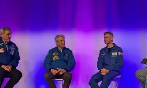 John McFall et d’autres astronautes assis lors d’une conférence.