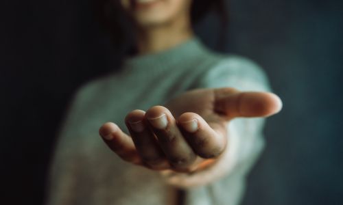 Une femme tend la main.