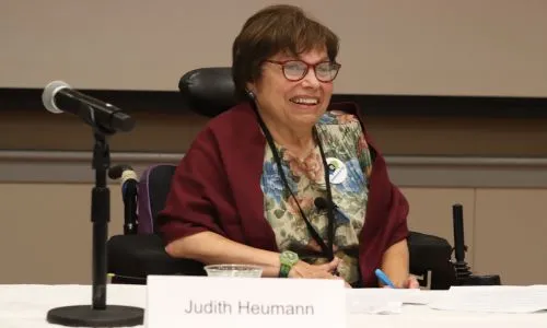 Judy Heumann assise &agrave; une table.