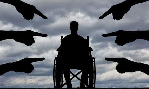 Une personne en fauteuil roulant pointée du doigt par 6 personnes.