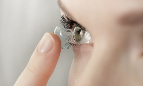 Une femme met sa lentille de contact