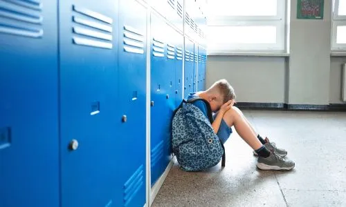&Eacute;colier triste assis dans le couloir de l'&eacute;cole