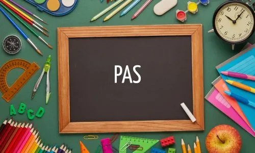 Un tableau noir sur lequel est écrit « PAS », entouré de crayons, équerres...