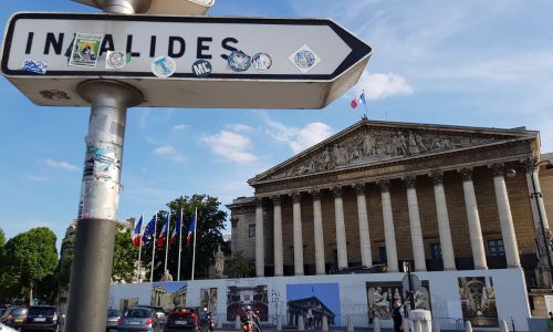 Assemblée nationale à Paris derrière un panneau mentionnant Invalides.
