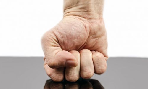 Un homme écrase son poing sur une table.