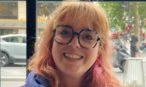 Margault, jeune femme aux cheveux rouges et à lunette, souriante