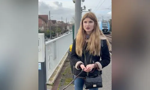 Samantha Lefebvre avec son chien guide devant un quai de gare.