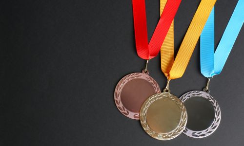 M&eacute;dailles d'or, d'argent et de bronze sur fond sombre.