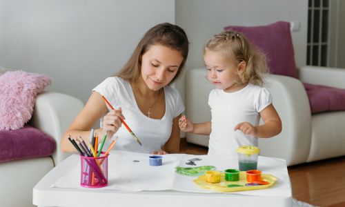 Une mère en train de peindre avec sa fille.