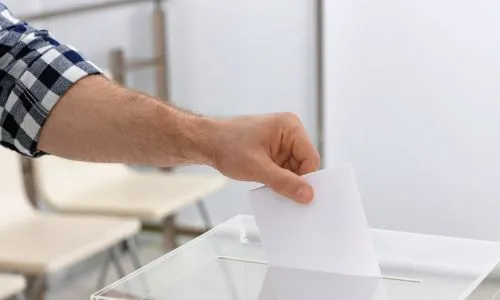 Un homme d&eacute;pose son bulletin de vote dans l'urne d'un bureau de vote.
