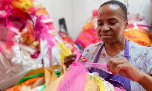 Nnena Kalu en train de confectionner une de ses œuvres colorées.