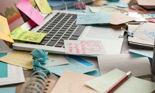 Papiers &eacute;parses devant un ordinateur