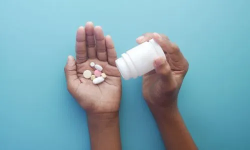 Mains qui tiennent des pilules.