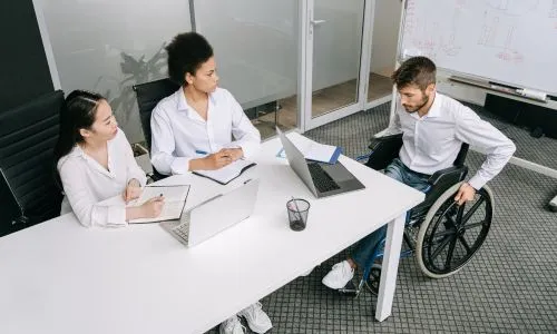 Jeune homme en fauteuil roulant avec d’autres collègues
