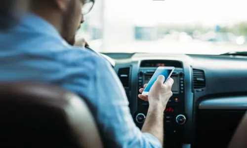Homme utilisant son téléphone dans sa voiture.