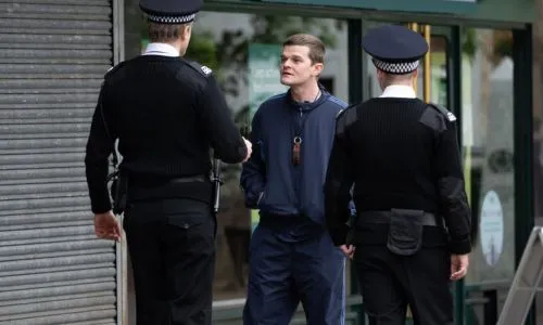 Un jeune homme devant des policiers britanniques