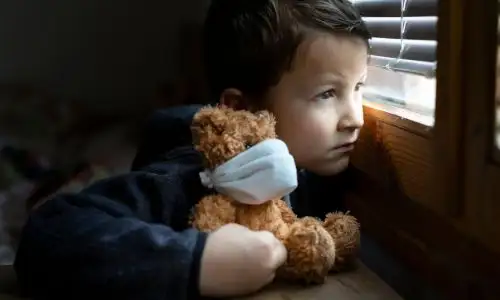 enfant isol&eacute; et triste regardant par la fen&ecirc;tre