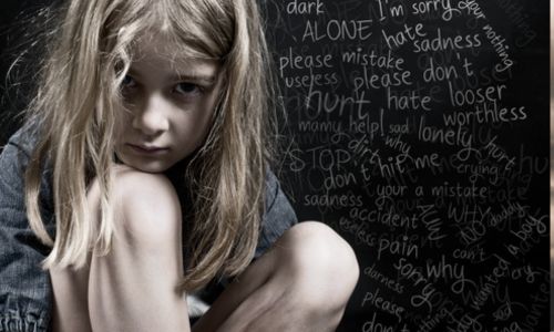 Une jeune fille recroquevillée devant un fond noir qui liste des mots anxiogènes