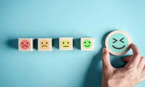 Cinq smileys, du plus triste au plus heureux, côte à côte.