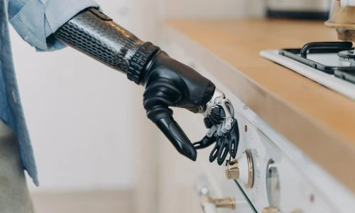 Une personne handicap&eacute;e portant une proth&egrave;se de bras utilise un appareil m&eacute;nager