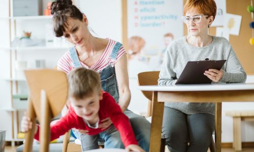 Un enfant TDAH avec sa mère devant un professionnel de santé.