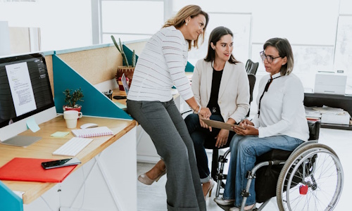 Trio de personnes dans un bureau dont une en fauteuil roulant