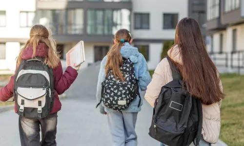 Des &eacute;l&egrave;ves se rendent &agrave; l'&eacute;cole &agrave; pied avec leur sac &agrave; dos.
