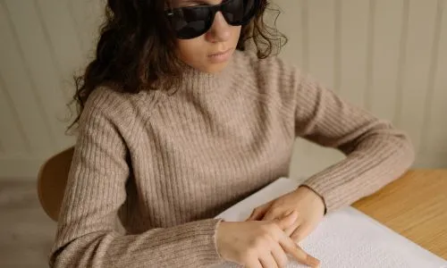 Jeune femme aveugle qui lit du braille