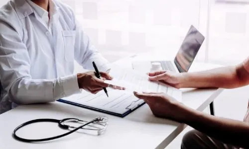 Un m&eacute;decin donne une ordonnance &agrave; un patient.