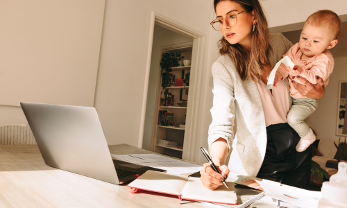 une maman en t&eacute;l&eacute;travail avec son enfant dans les bras