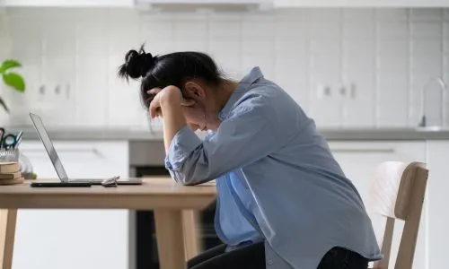 Jeune femme ind&eacute;pendante d&eacute;prim&eacute;e devant son ordinateur.