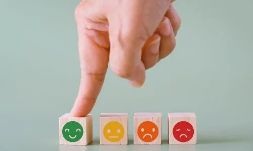 Un index touche un cube avec un smiley sourire.