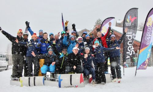 Un groupe de skieurs lèvent les bras dans la neige.