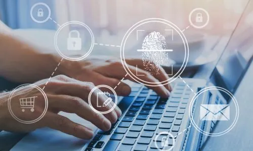 Des mains qui pianotent sur un ordi portable.