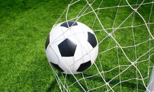 Un ballon de foot au fond des filets.