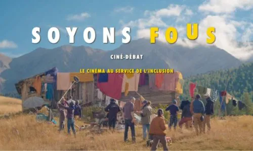 Un plateau de tournage sous un ciel bleu et devant une montagne.