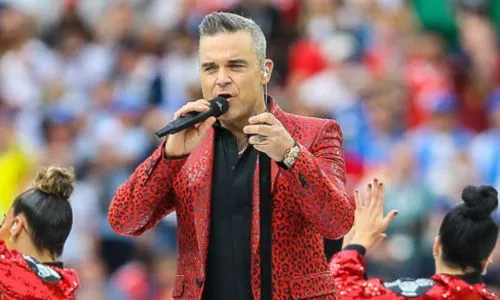 Robbie Williams sur sc&egrave;ne, habill&eacute; de rouge