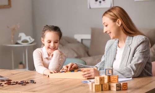 Petite fille qui joue à des jeux de logique avec une femme.