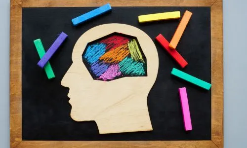 La t&ecirc;te est peinte aux crayons de couleur. Concept de neurodivergence.