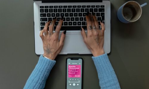 Une femme écoute le podcast « En toutes circonstances » et prend des notes.