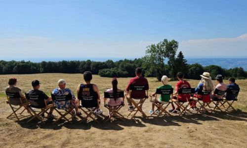 Les comédiens d’Un p’tit truc en plus, de dos, sur une chaise, sur le tournage