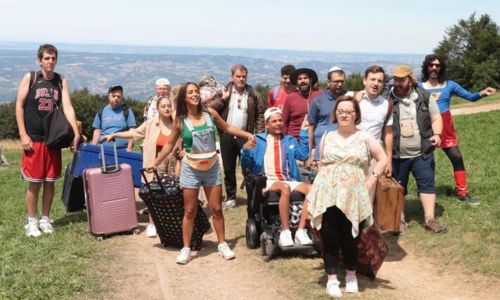 Le groupe de vacanciers sur un chemin de montagne avec leurs bagages.