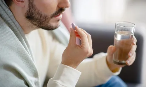 Un homme prend un médicament.