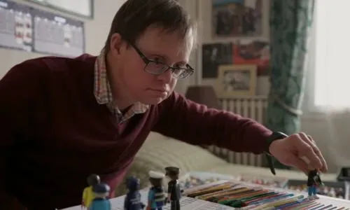 Un homme avec trisomie 21 joue aux Playmobil.