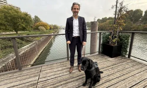 Vincent Julé avec son labrador noir, en laisse, devant la Seine
